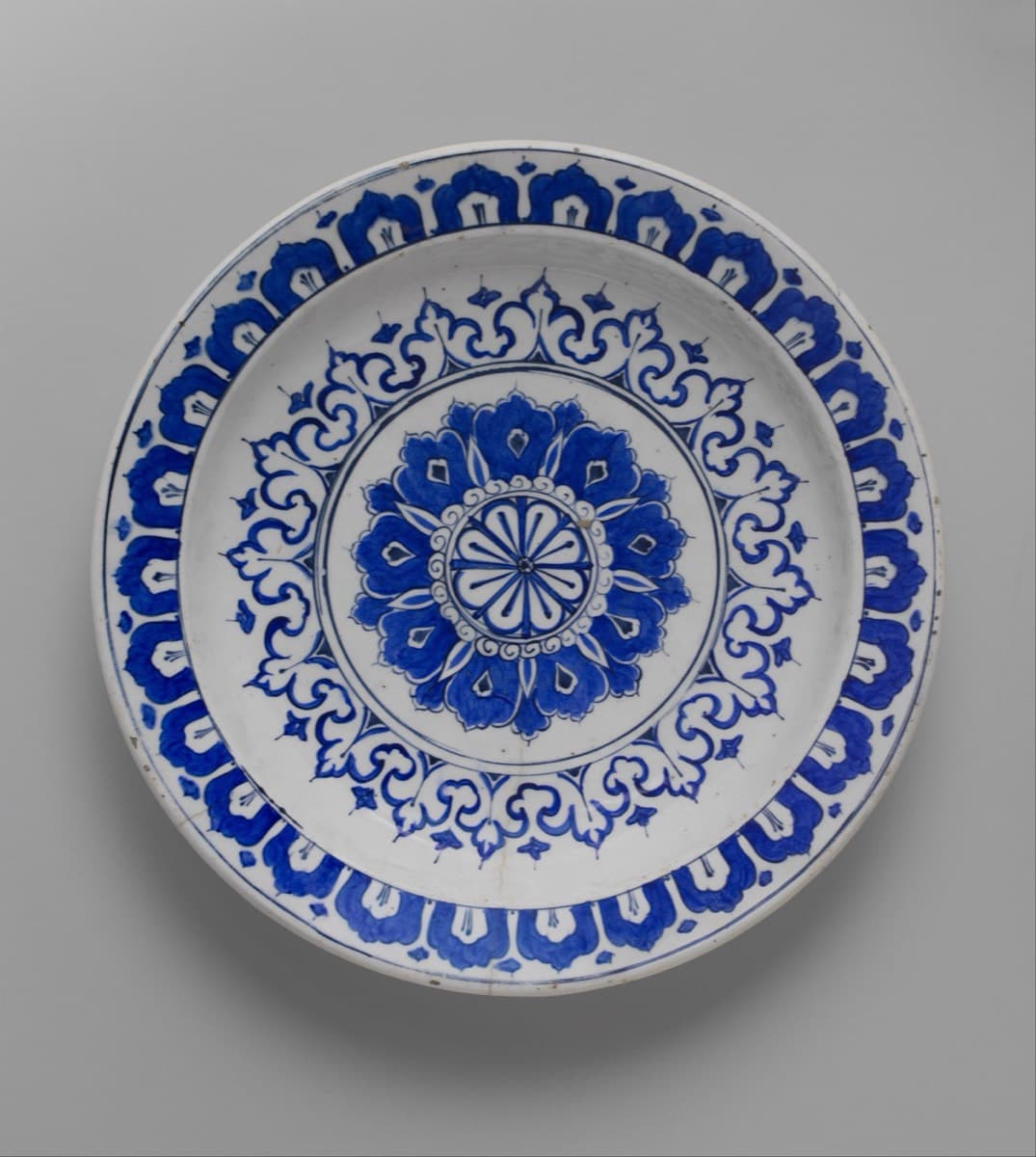 Weiße Schale mit kobaltblauer Rosette, Rankenkranz und Rand aus Wolkenbändern.